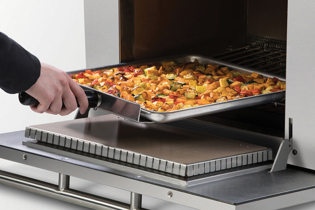 XC4i_cavity_close-up_veggies_SQ10_PA10 High-speed ovens give operators without traditional kitchens the opportunity to offer hot menu items, such as roasted vegetables. The door on this model drops down for safe removal of food from the cavity. Courtesy of ACP.