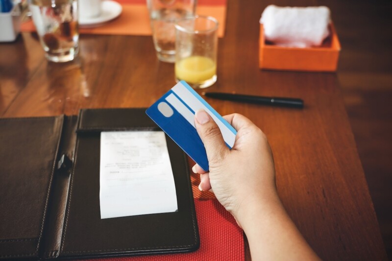 Selective focus of woman hand with credit card which she is a receipt bill food and drink for payment by credit card in the table at restaurant