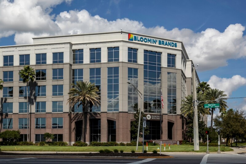 Tampa, Florida, USA February 23, 2020: Sign and logo of Bloomin' Brands on the building of its headquarters in Tampa, Florida, USA, a company owns several American casual dining restaurant chains.