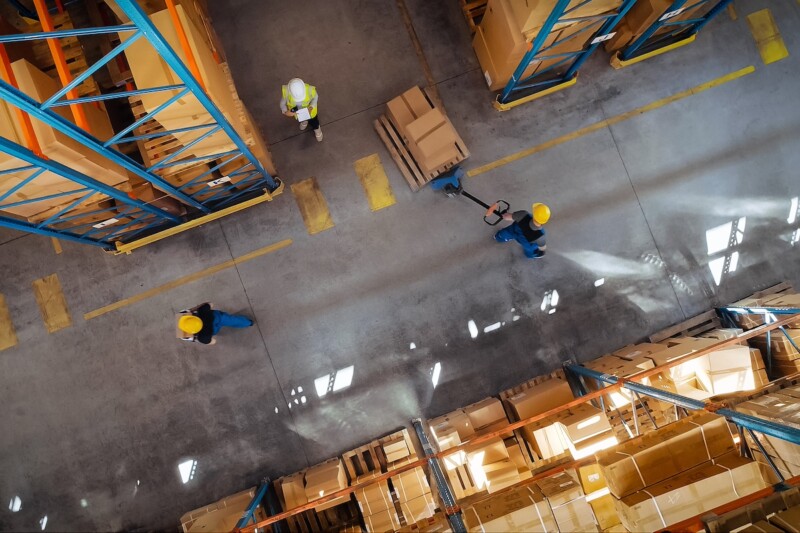Top Down View: In Warehouse People Working, Forklift Truck Operator Lifts Pallet with Cardboard Box. Logistics, Distribution Center with Products Ready for Global Shipment, Customer Delivery