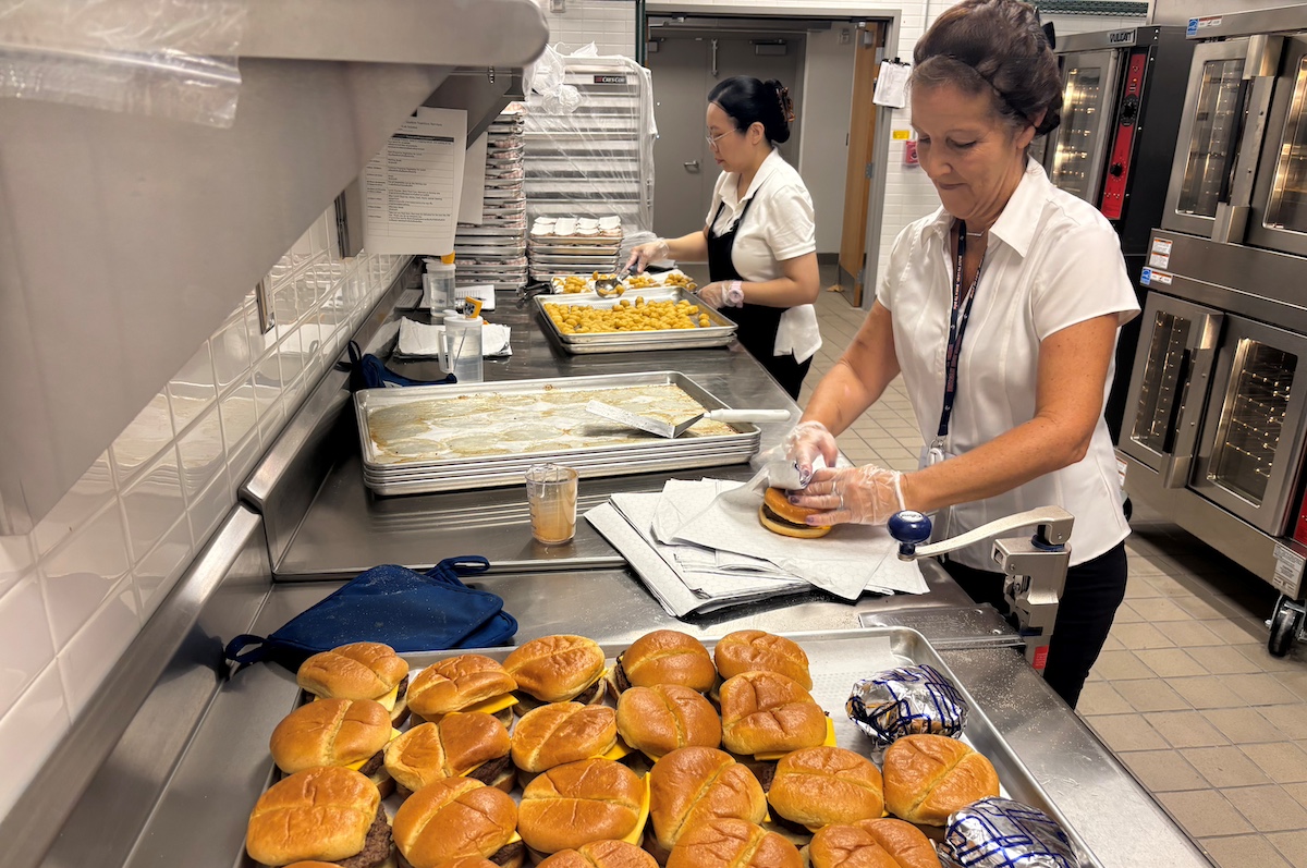kitchen workers prep burgers